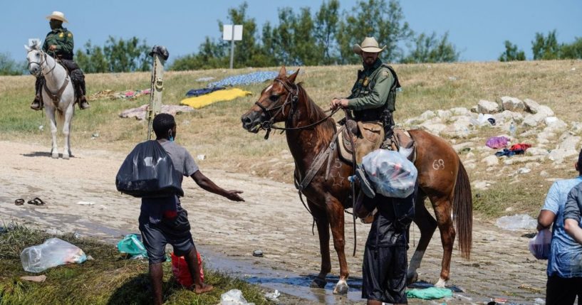 U.S. Border Patrol agents are seen interacting with Haitian migrants at the banks of the Rio Grande in Del Rio, Texas, on Sunday.