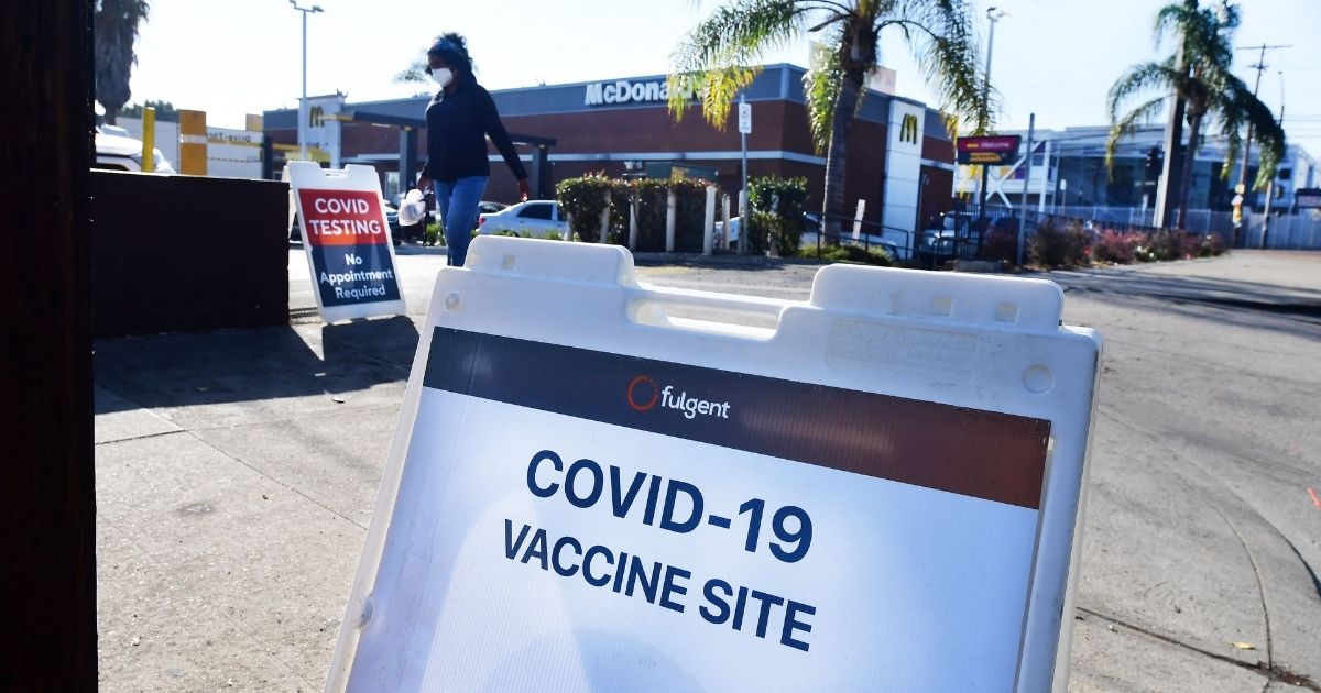 Signs telling people where to get the COVID vaccine are seen outside a McDonald’s and the California Department of Public Health on Sept. 21.