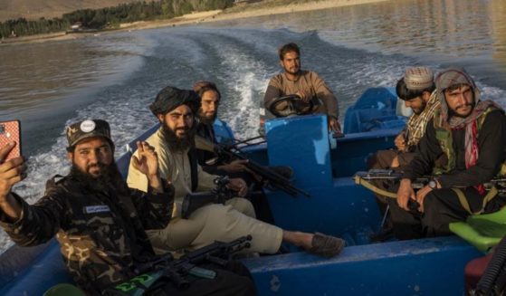 Taliban fighters are seen sitting in a boat at the Qargha dam on the outskirts of Kabul, Afghanistan, on Friday.