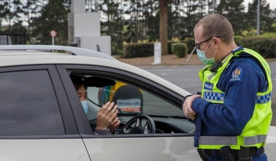 A police officer speaks to a driver wanting to leave Auckland, New Zealand, at a COVID-19 checkpoint on Aug. 14, 2020.