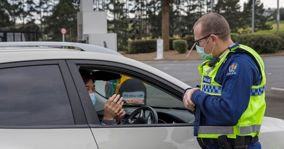A police officer speaks to a driver wanting to leave Auckland, New Zealand, at a COVID-19 checkpoint on Aug. 14, 2020.