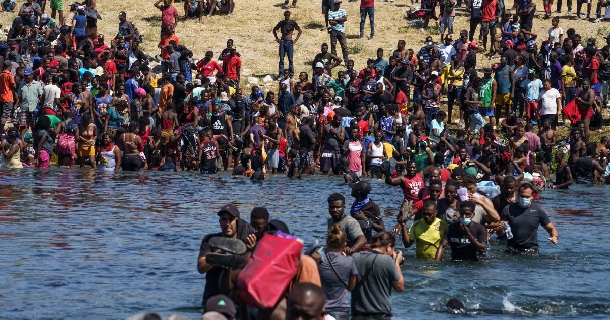 Some of a group of over 10,000 migrants from Haitian and other countries migrants are seen crossing the Rio Grande on Sunday.