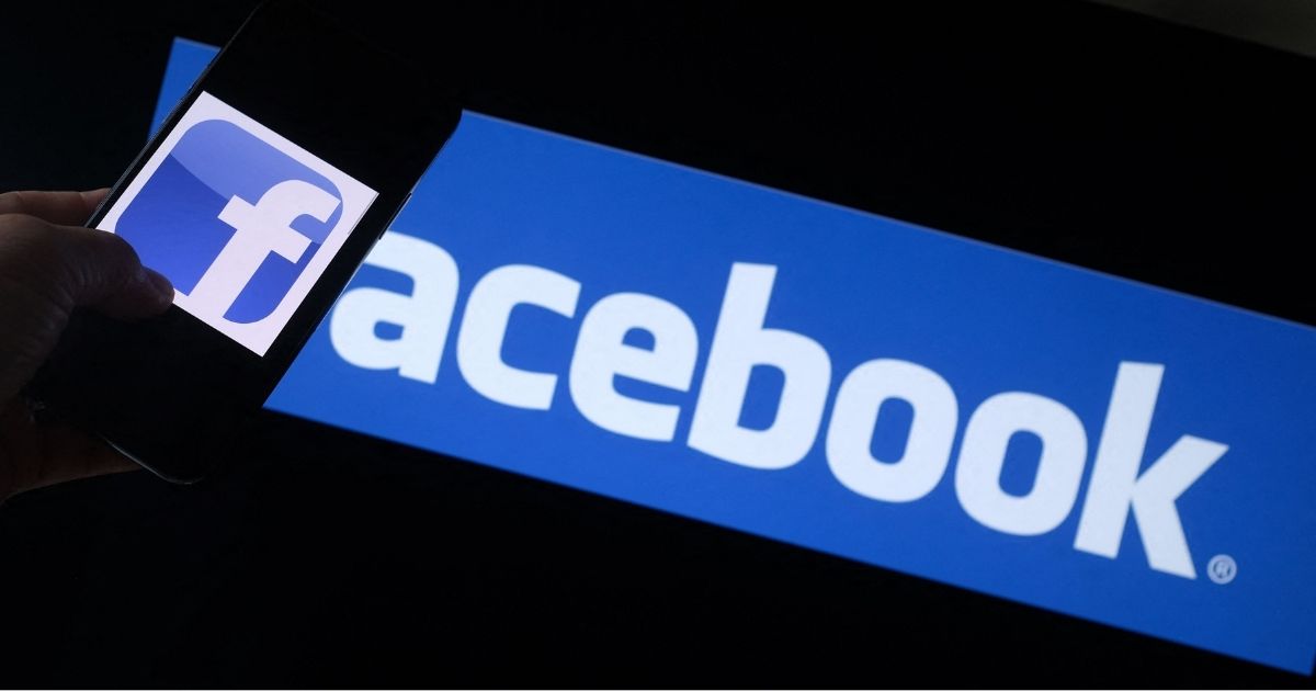 The Facebook logo is seen on a smartphone with a computer screen in the background in Los Angeles on Aug. 12.