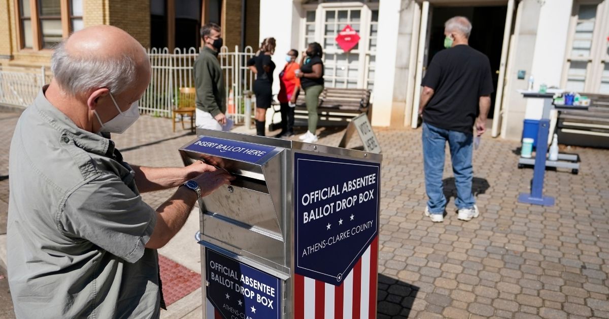 A voter turns in a ballot during early voting in Oct. 19, 2020, file photo from Athens, Georgia, in the Peach State's Athens-Clarke County.