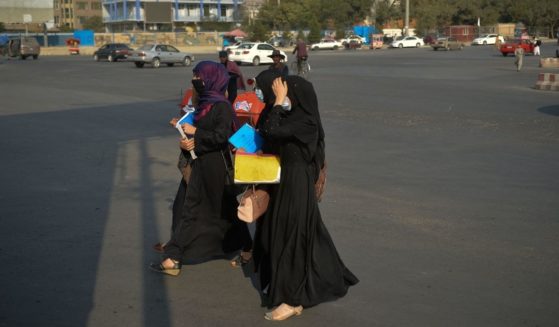 Afghan women clad in burqas are seen walking on a road in Kabul on Tuesday.