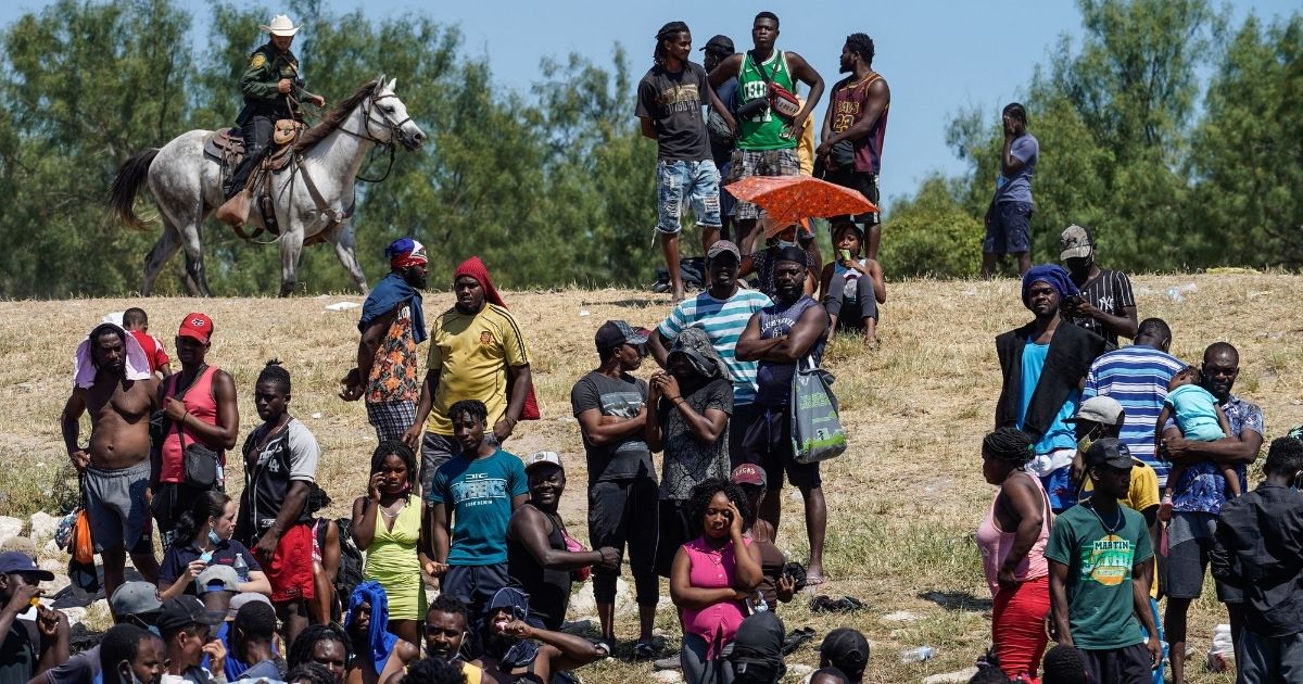 US Border Patrol Agents are seen on horseback near Haitian migrants at the banks of the Rio Grande River in Del Rio, Texas, on Sept. 19.
