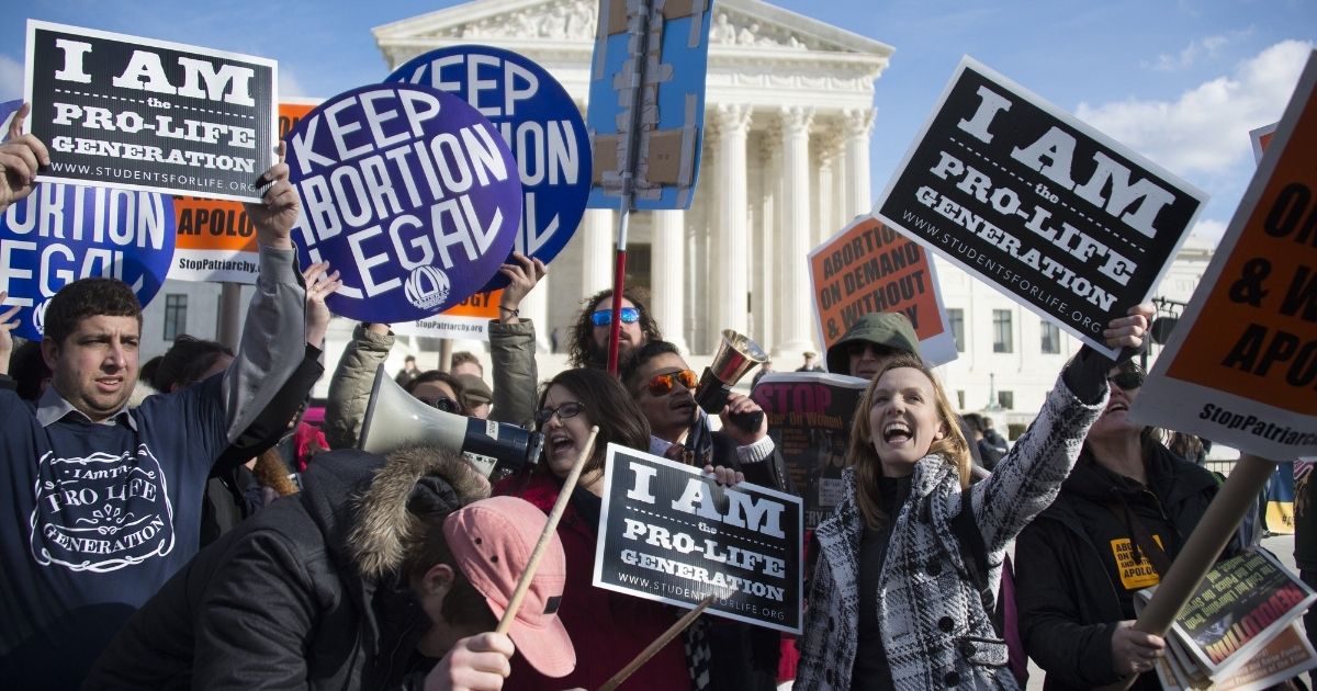 Pro-abortion and pro-life activists are seen outside the Supreme Court in Washington, D.C., on Jan. 22, 2015.