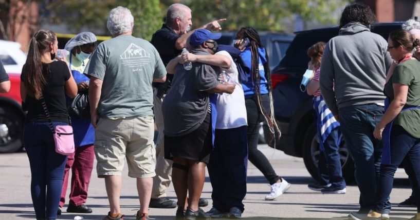 People are seen standing with police at the scene of a shooting at a Kroger’s grocery store in Collierville, Tennessee, on Thursday.