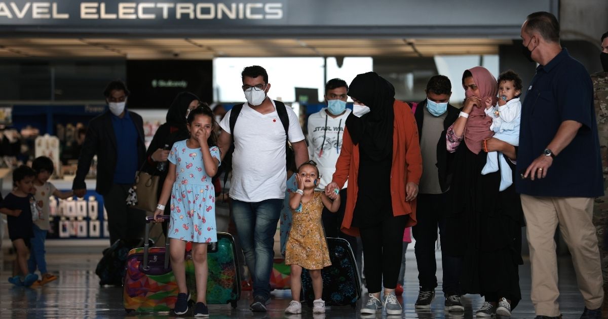 Refugees are led through the departure terminal to a bus at Dulles International Airport after being evacuated from Kabul following the Taliban takeover of Afghanistan on Aug. 31, in Dulles, Virginia.