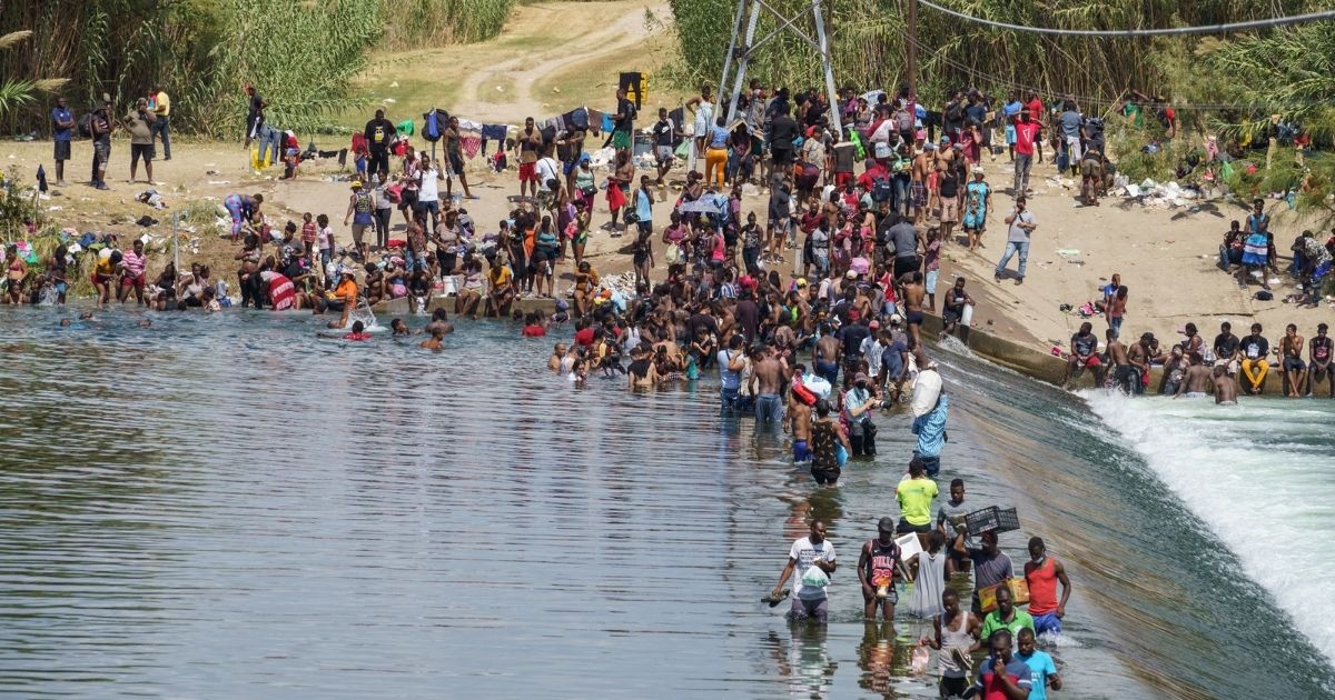 Migrants, many of them Haitian, cross the Rio Grande to get food and supplies near the Del Rio-Acuna Port of Entry in Ciudad Acuna, Coahuila state, Mexico on Saturday.