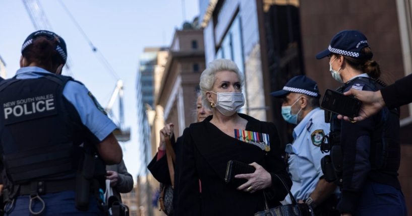 A protester stands near several police officers while speaking to the media during an anti-lockdown protest on Monday in Sydney.