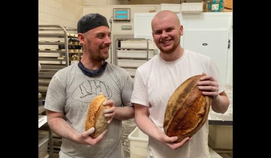 Two employees hold up loaves of bread made at Freedom Bakery, which gives inmates skills to help them reintegrate into society.