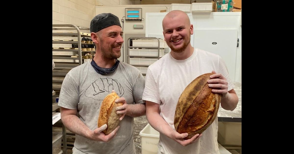 Two employees hold up loaves of bread made at Freedom Bakery, which gives inmates skills to help them reintegrate into society.