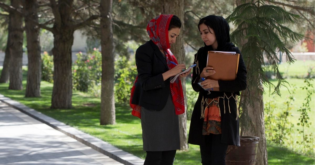 Adela Raz, left, talks to a female Afghan journalist while waiting for a news conference in October 2013.