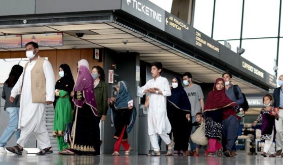 Afghan refugees walk through the departure terminal to a bus at Dulles International Airport in Virginia on Aug. 31 after being evacuated from Kabul following the Taliban takeover of Afghanistan.