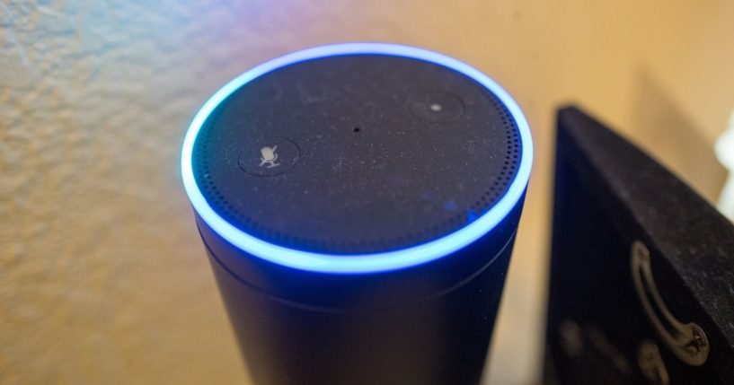 A close-up photo is taken of an Amazon Echo smart speaker and voice assistant with illuminated blue light ring, a device which uses the Amazon service to recognize and respond to users' voice commands, on May 7, 2018.