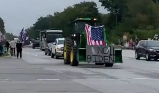 Hundreds of protesters with American flags and Trump signs and a John Deere tractor with a "No Biden" sign were seen along the street in Michigan as they waited to greet President Biden.