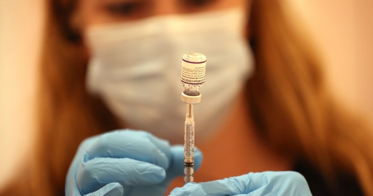 A pharmacist fills a syringe with the Pfizer COVID-19 booster vaccination at a clinic on Oct. 1 in San Rafael, California.
