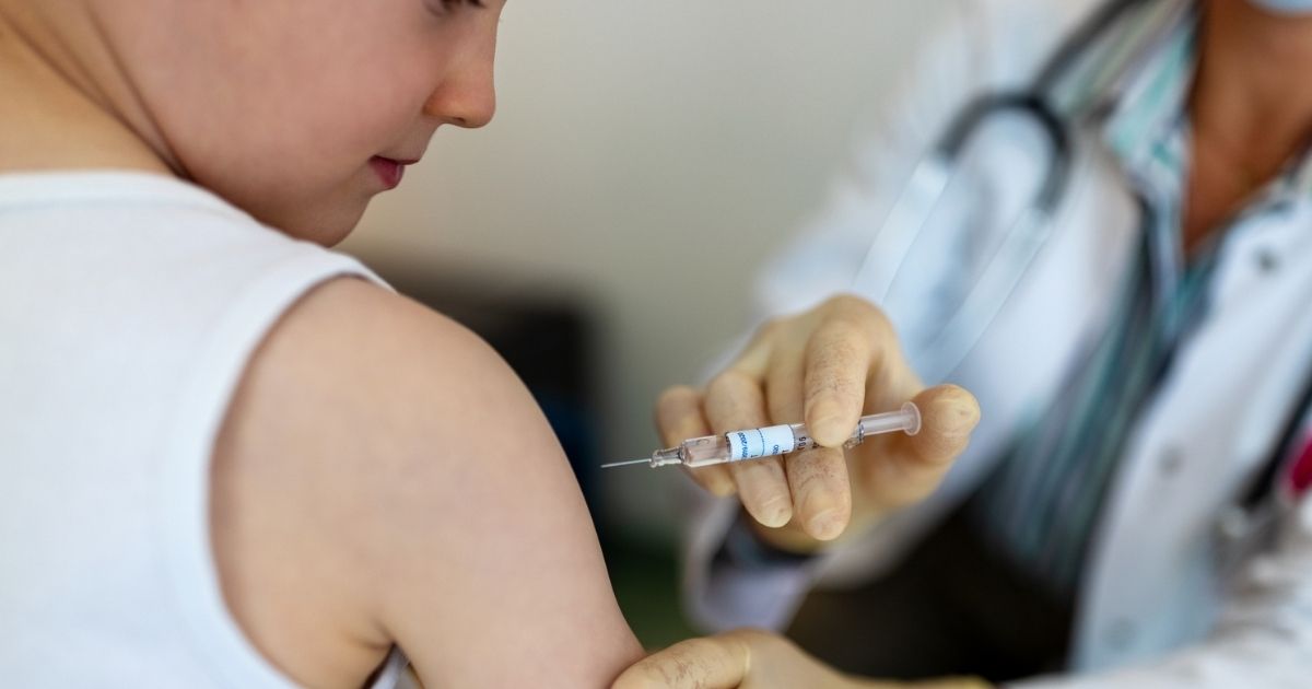 A child receives a vaccine from a doctor