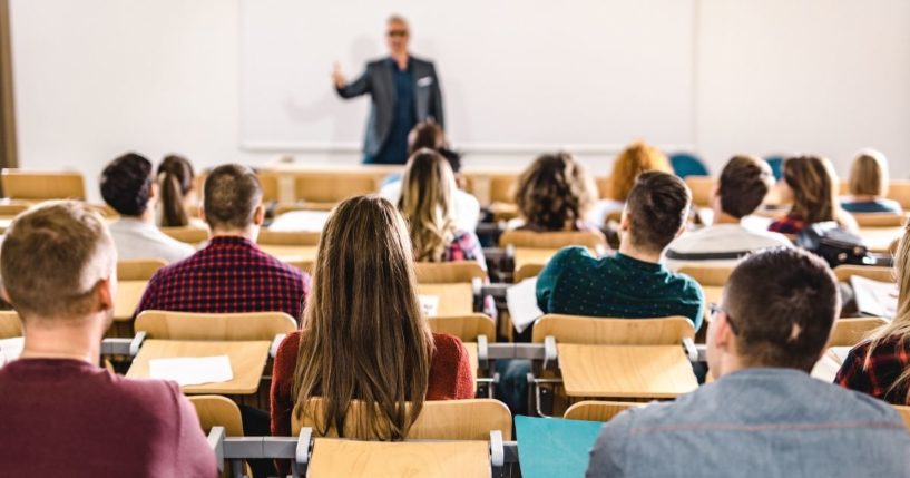 A classroom of college students is pictured in the stock image above.