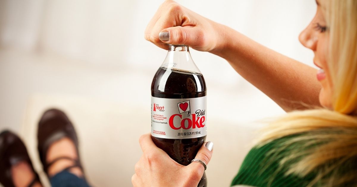 A woman is pictured opening a bottle of Diet Coke in the stock image above.
