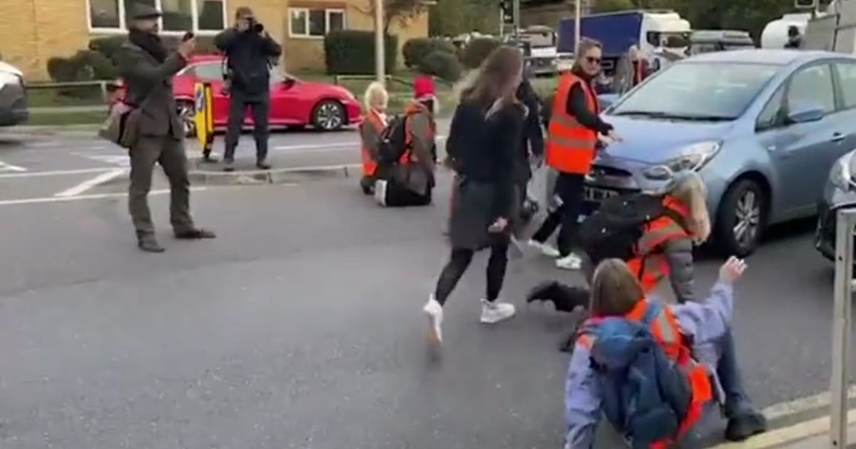 Environmental protesters in London are dragged off the street by frustrated drivers.