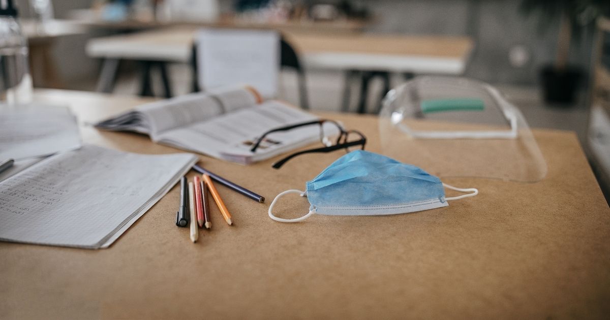 This stock image shows a face mask lying on a desk with other school supplies. A teenager attending McNeel Intermediate School in Beloit, Wisconsin, alleged a teacher duct-taped a mask to his face.