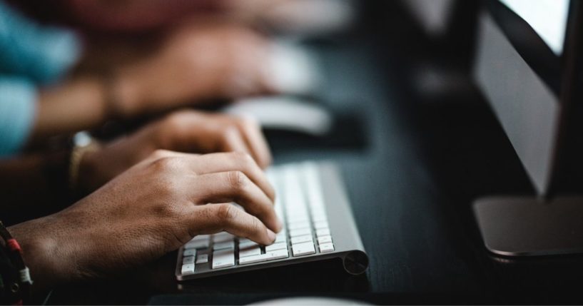 This stock image portrays workers typing on computer keyboards. Federal investigators are reportedly issuing 