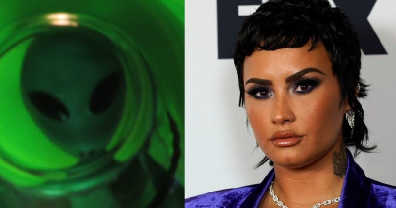 A green alien is pictured next to famous pop star Demi Lovato, who is in attendance at the iHeartRadio Music Awards in May.