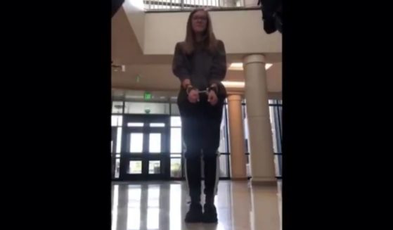 A high school student is placed in handcuffs and removed from school after refusing to wear a mask inside.