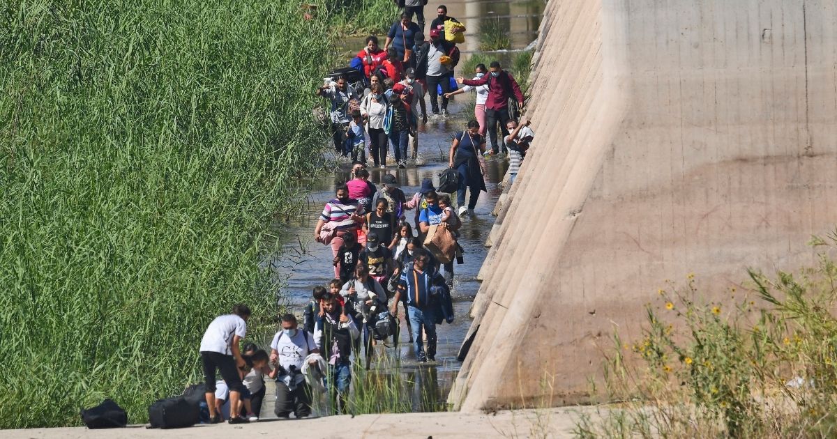 Migrants illegally cross the border from Mexico into San Luis, Arizona on Sunday.