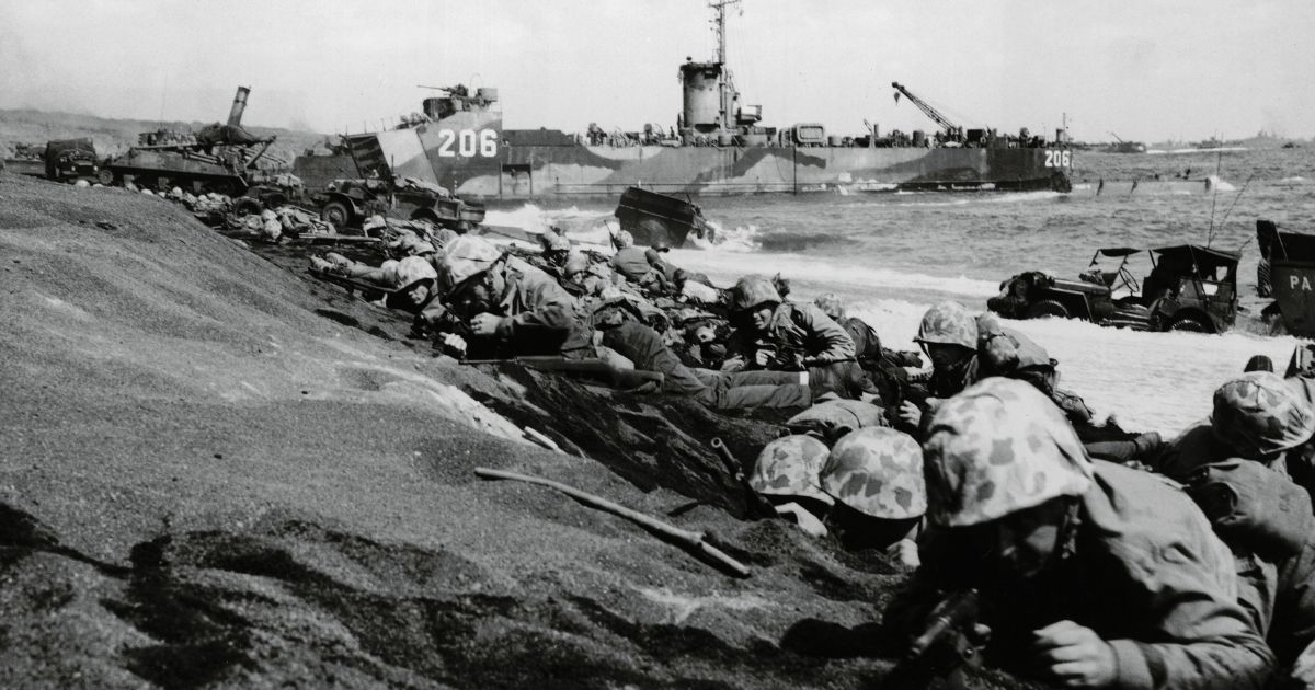 United States Fourth Division Marines take cover from enemy fire on the shores of Iwo Jima during World War II in Japan on Feb. 19, 1945.