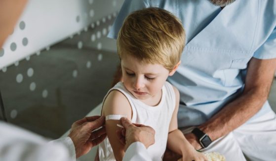 A doctor puts a bandage on a child's arm