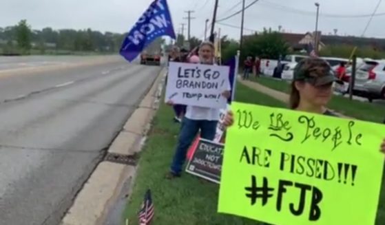 An Illinois street was recently lined with people waiting to greet President Joe Biden, but the signs they displayed were surprisingly unfriendly, considering Illinois is such a deep-blue state. Messages included banners supporting Donald Trump and also included various versions of a profane chant that has been making the rounds and which was recently mistakenly interpreted by a television broadcaster as saying, "Let's Go, Brandon."