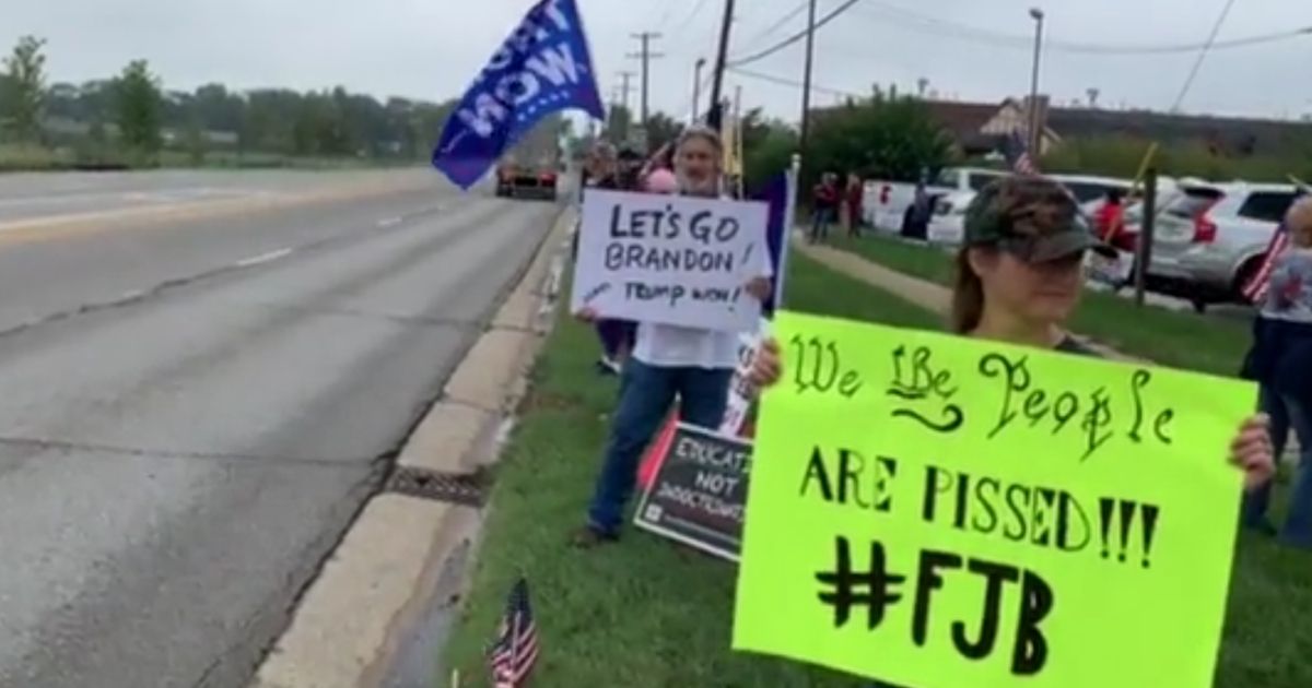 An Illinois street was recently lined with people waiting to greet President Joe Biden, but the signs they displayed were surprisingly unfriendly, considering Illinois is such a deep-blue state. Messages included banners supporting Donald Trump and also included various versions of a profane chant that has been making the rounds and which was recently mistakenly interpreted by a television broadcaster as saying, "Let's Go, Brandon."