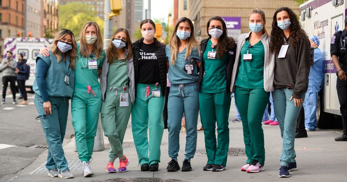 Medical workers stand outside NYU Langone Health hospital in New York City as people applaud to show their gratitude to medical staff and essential workers during the coronavirus pandemic on May 12, 2020.