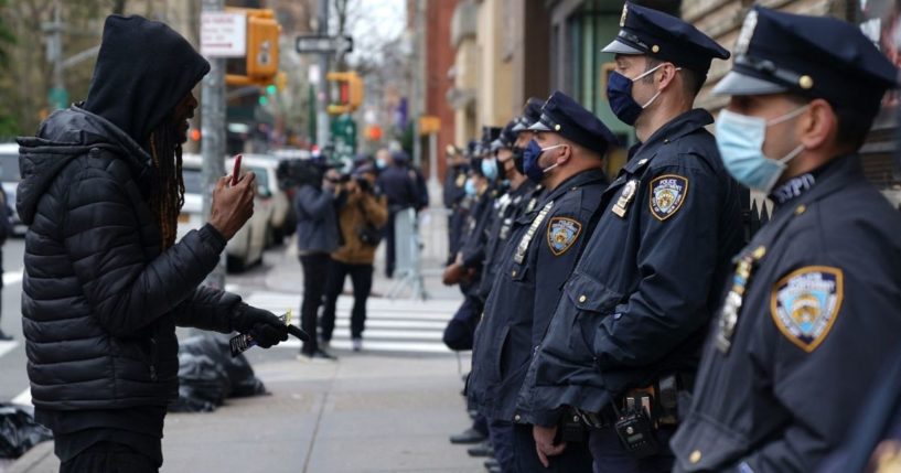 A protester confronts New York Police Department officers outside Washington Square Park in New York on April 12.
