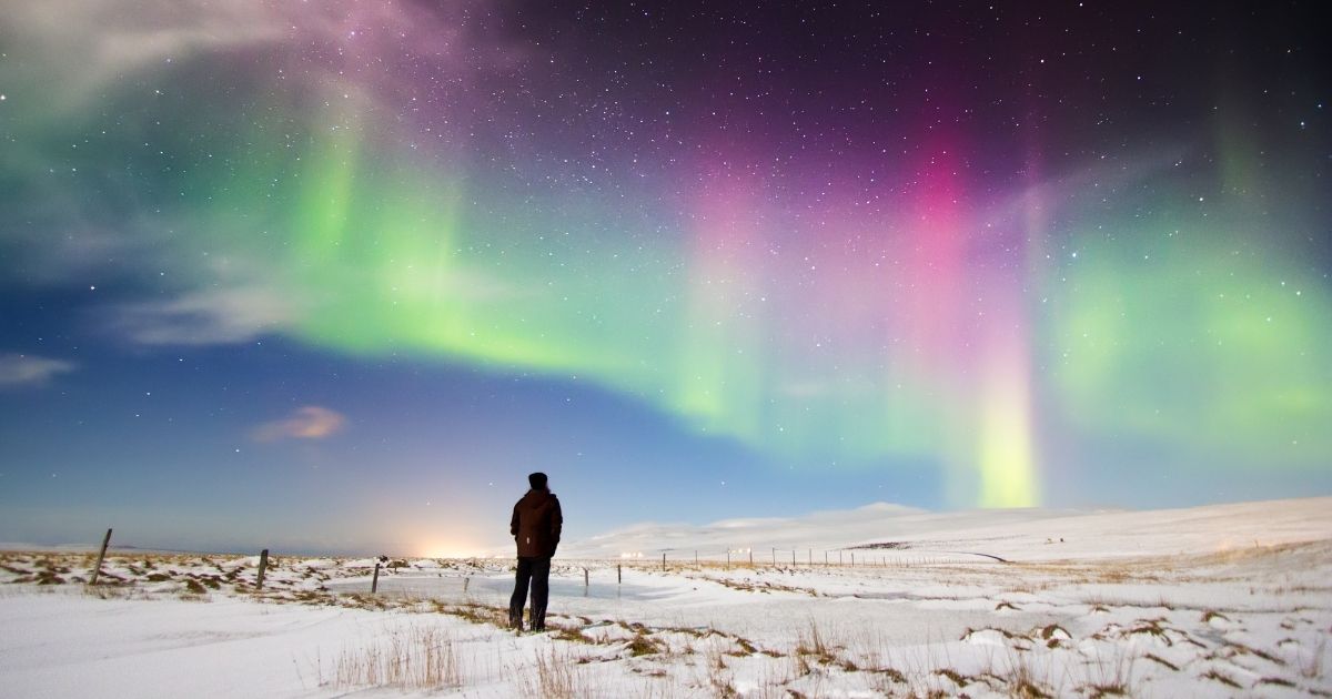 This stock image shows a man looking up at the aurora borealis in north Iceland. This weekend, many northern states in America may witness the lights.