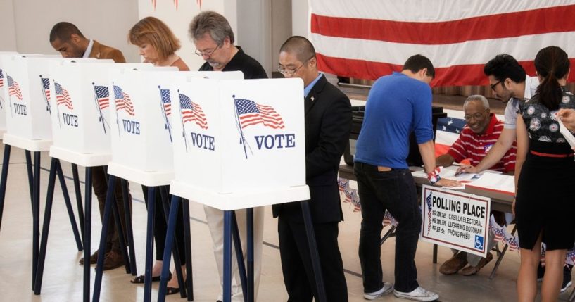 People are pictured voting in the stock image above.
