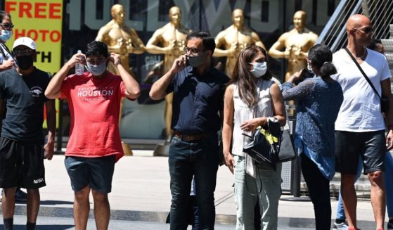 People wearing masks wait to cross the street in Hollywood, California, on July 19, 2021.