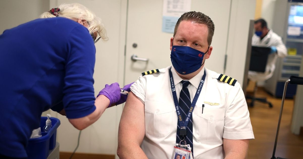 United Airlines pilot Steve Lindland receives a COVID-19 vaccine from RN Sandra Manella at United's onsite clinic at O'Hare International Airport in Chicago on March 9.