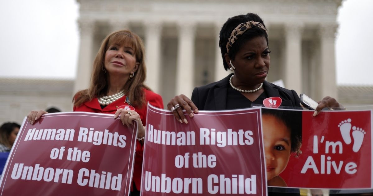 Pro-life activists hold signs during a rally in front of the U.S. Supreme Court on Oct. 12 in Washington, D.C.