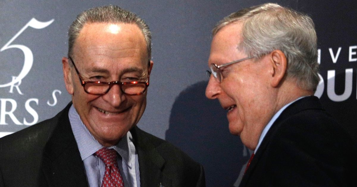Then-Senate Majority Leader Mitch McConnell, right, and Minority Leader Chuck Schumer shake hands after Schumer spoke at the University of Louisville's McConnell Center in Louisville, Kentucky, on Feb. 12, 2018.