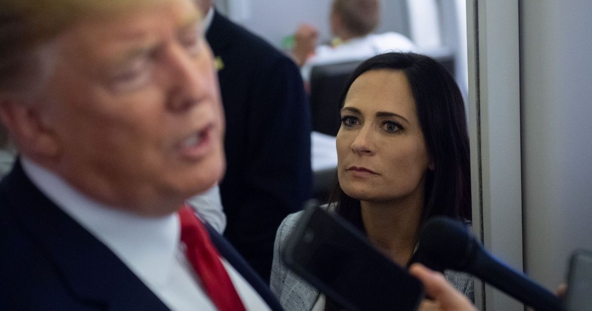 Then-White House press secretary Stephanie Grisham listens as President Donald Trump speaks to the media aboard Air Force One while flying from El Paso, Texas, to Joint Base Andrews in Maryland on Aug. 7, 2019.