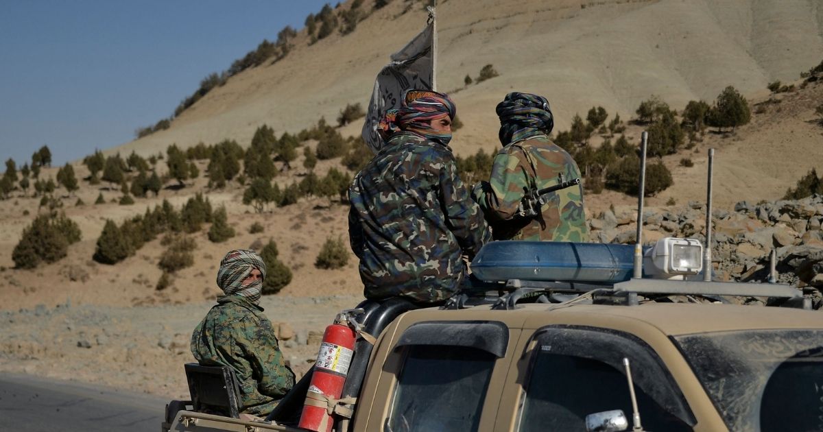 Taliban fighters travel on a pick-up truck along a road in Band Sabzak area in Badghis, Afghanistan, on Sunday.