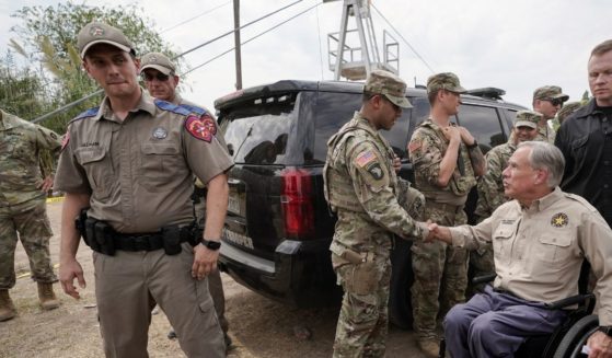 Texas Gov. Greg Abbott meets with Texas National Guard members after giving a news conference along the Rio Grande on Sept. 21.