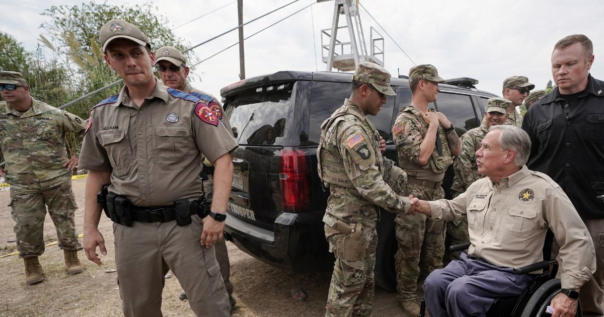 Texas Gov. Greg Abbott meets with Texas National Guard members after giving a news conference along the Rio Grande on Sept. 21.