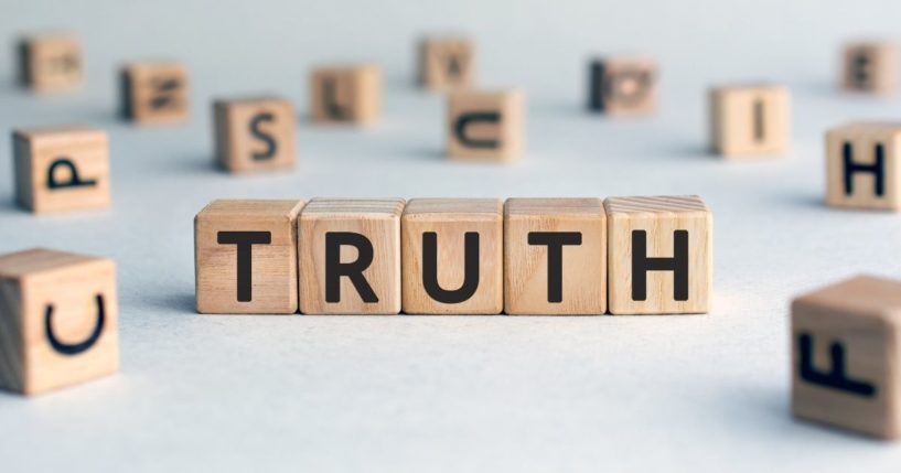Wooden blocks with letters spelling the word "truth" are seen in the stock image above.
