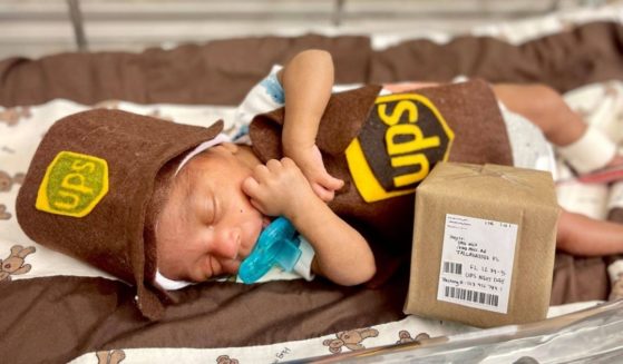 A NICU baby dressed in a UPS costume