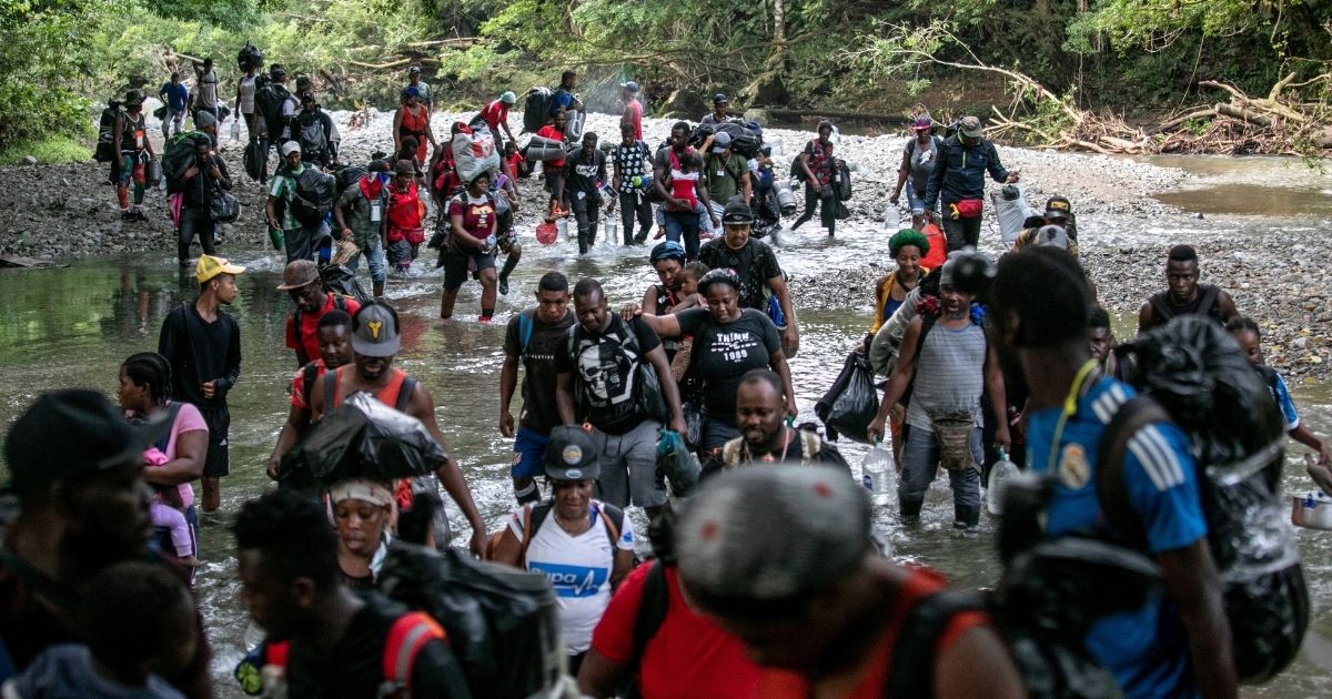 Migrants, most from Haiti, ford one of many rivers they will cross while on a trek through the infamous Darien Gap on their journey towards the United States on October 07, near Acandi, Colombia.